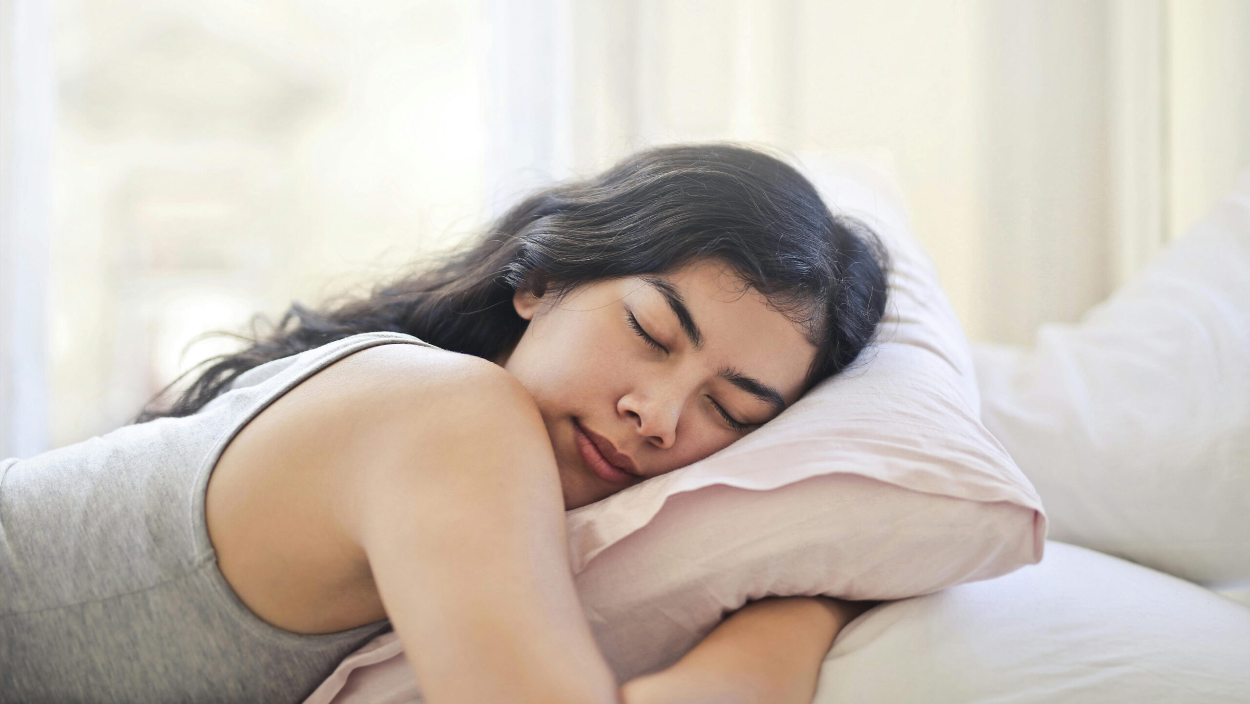 Woman sleeping peacefully after using THC oil—exploring how long THC oil lasts, its effects, and how to take cannabis oil safely in the UK.