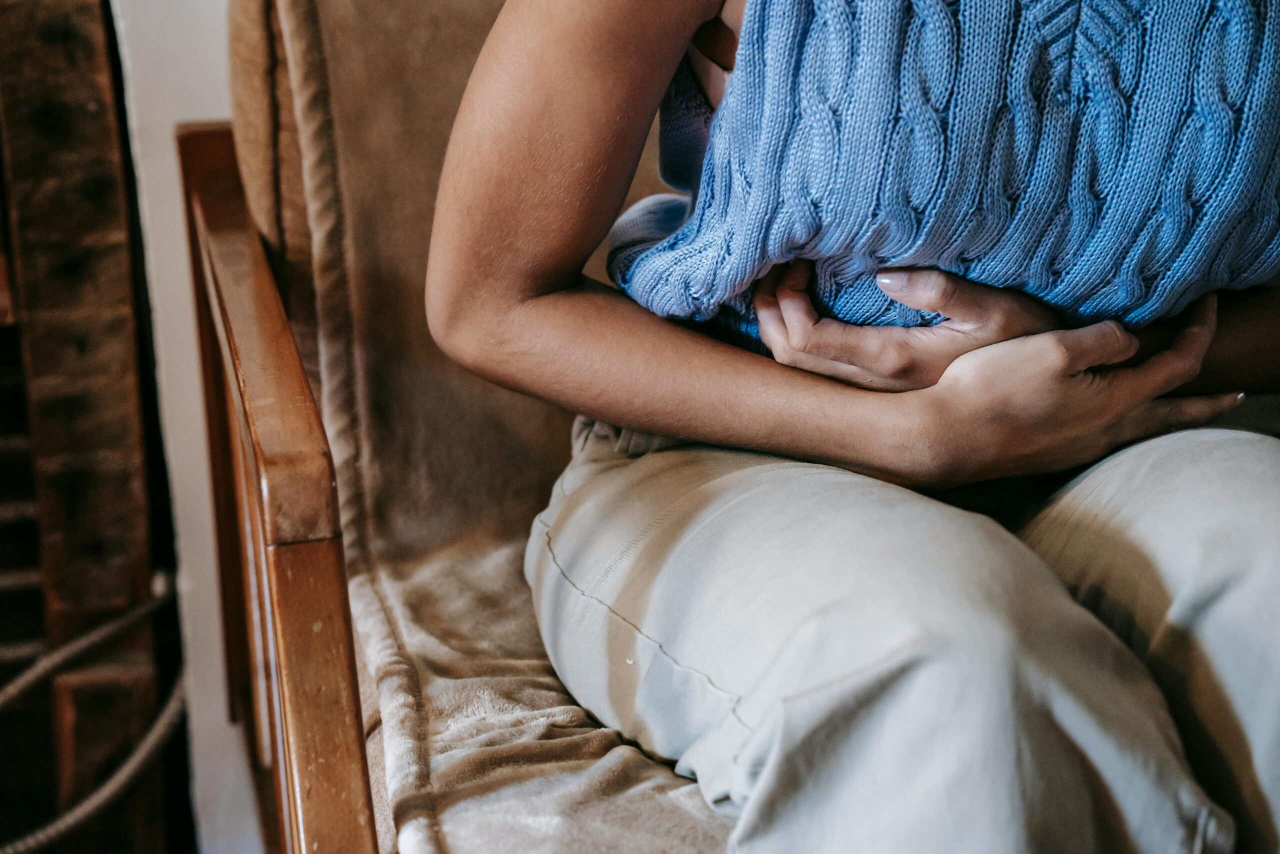 Female patient experiencing abdominal pain, wondering about medical cannabis treatment on the NHS.