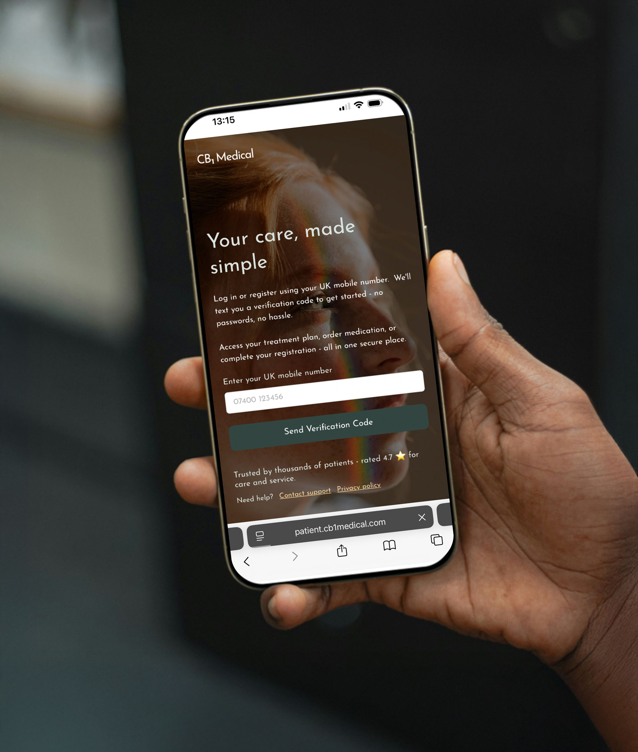A hand is holding a mobile phone with the CB1 Patient Platform log in page on screen.
